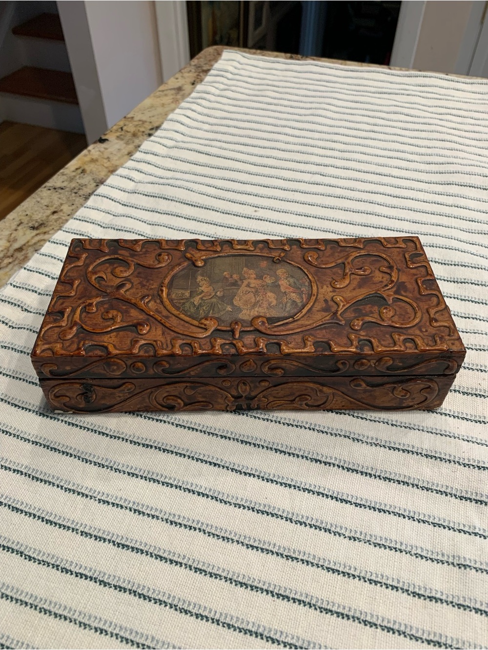 Vintage wooden trinket box featuring ornate carved scrollwork